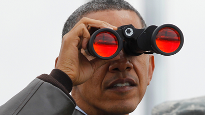 President Barack Obama looks through binoculars to see North Korea from Observation Post Ouellette in the Demilitarized Zone, the tense military border between the two Koreas, in Panmunjom, South Korea, Sunday, March 25, 2012.