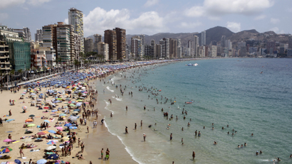 People relax at the beach during a hot summer day in Benidorm, Spain.