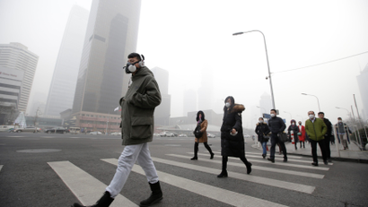 A man wearing a respiratory protection mask walks toward an office building during the smog after a red alert was issued for heavy air pollution in Beijing's central business district, China, December 21, 2016. REUTERS/Jason Lee TPX IMAGES OF THE DAY - RTX2VY34