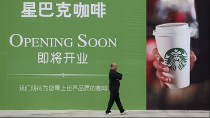 A man walks past an advertisement board of Starbucks in Wuhan, Hubei province, in this October 29, 2013 file photo. A China state television investigative report accusing Starbucks of overcharging local customers for coffee triggered enormous disquiet among journalists at the network and even some soul-searching after it aired. December 16, 2013
