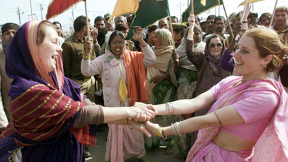 FOREIGN TOURISTS DRESSED IN TRADITIONAL SARIS DANCE WITH INDIANS DURING THE MAHA KUMBH MELA FESTIVAL ...