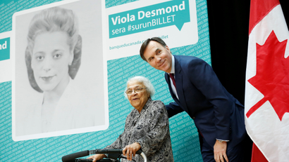 Canada's Finance Minister Bill Morneau stands with Wanda Robson after her sister Viola Desmond was chosen to be featured on a new $10 bank note during a ceremony at the Museum of History in Gatineau, Quebec, Canada, December 8, 2016. REUTERS/Chris Wattie TPX IMAGES OF THE DAY - RTSV8X4