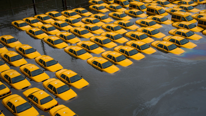A flooded parking lot full of taxis.