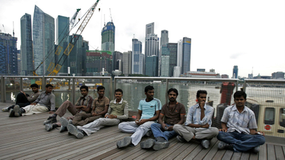 Migrant workers from the Indian sub-continent on their day off sit on an outdoor viewing platform at the recently opened Marina Bay Sands integrated resorts in Singapore August