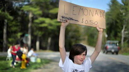 Cooper Jacobs tries to attract motorist's to his family's lemonade stand in Freeport, Maine.