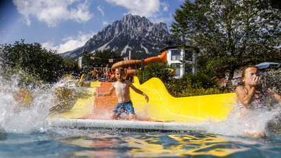 Children slide down a water slide on a hot summer day in the western Austrian village of Ellmau.