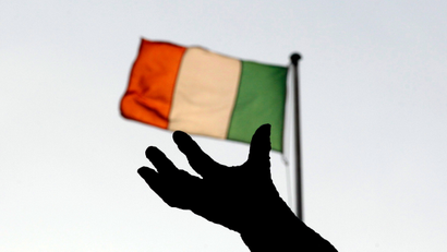 Ireland's national flag flies above a statue on O'Connell Street in Dublin December 5, 2011. Ireland's government on Monday unveils what it hopes will be the toughest budget of its five-year term, but as it tries to keep the public onside economists are warning that a global downturn means the worst may be yet to come.