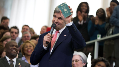New Secretary of State John Kerry shows his first diplomatic passport he got when he was eleven years old when his father was in the foreign service, Monday, Feb. 4, 2013, during a ceremony welcoming him as the 68th secretary of state, at the State Department in Washington.