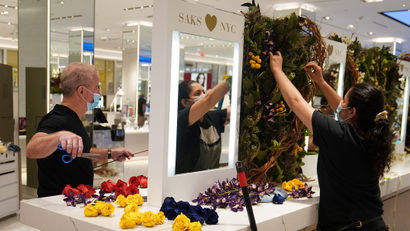 Workers put up a flower display at Saks 5th Avenue in the Manhattan borough of New York City