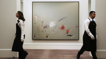 Employees pose for a photograph with artist Cy Twombly's artwork "Untitled (Rome)" at Sotheby's auction house in London.