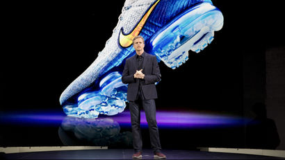 Mark Parker stands in front of a screen featuring Nike sneakers