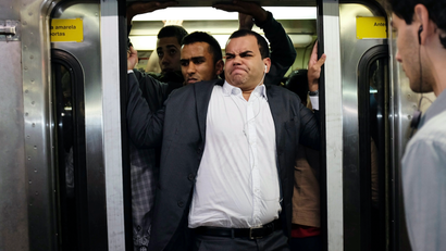 A commuter tries closing the door of a crowded train.