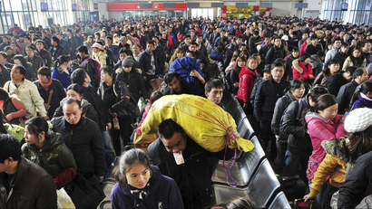 In this photo taken on Tuesday, Jan. 31, 2012, passengers wait to board trains at a railway station in Changsha, in central China's Hunan province. Millions of Chinese are expected to cram into China's train and bus network to return from home to work after the week-long Chinese Lunar New Year.