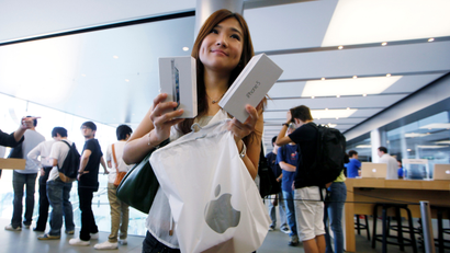 A customer shows her new iPhone 5 at the Apple store in Hong Kong Friday, Sept. 21, 2012. Apple fans lined up overnight in Australia while in Hong Kong they registered online for a chance to buy the iPhone 5, the latest version of the high-tech juggernaut’s iconic smartphone, as soon as it went on sale on Friday.