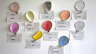 Drawings of balloons in different colours are seen in classroom
