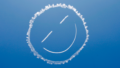 A sky writer creates a smiley face in the sky