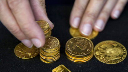 A worker places gold coins on display at Hatton Garden Metals precious metal dealers in London, Britain July 21, 2015. REUTERS/Neil Hall/File Photo - D1AETMHCTHAA
