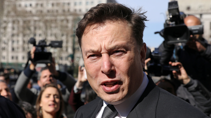 Elon Musk talks to reporters