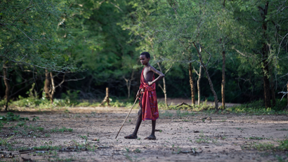 A young Maasai herder boy stands in the bush at the end of the day near Mikumi National Park in Tanzania, Friday, March 23, 2018.
