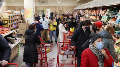 People shop in a grocery store in Manhattan.