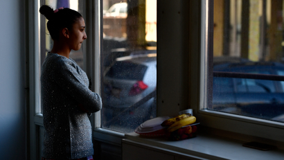 A women in Ukraine looks out of a window.