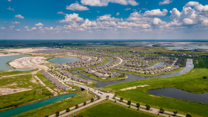 An aerial photo of a housing development built at the edge of a lake on low-lying ground.