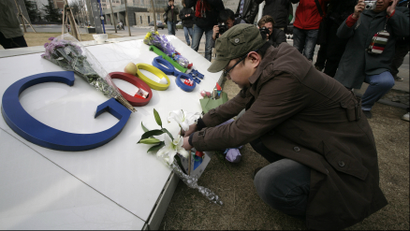 A man places flowers on the Google logo at its China headquarters building in Beijing March 23, 2010. Google Inc shut its mainland Chinese-language portal and began rerouting searches to an uncensored Hong Kong-based site, unleashing a blast of ire from Beijing and prompting concerns over its future business in China. This logo has been updated and is no longer in use.
