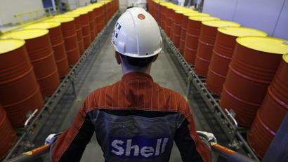 An employee stands in front of lines of oil barrels at Royal Dutch Shell Plc's lubricants blending plant in Russia