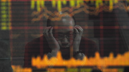 An investor is reflected in a screen showing stock information at a brokerage house in Hefei, Anhui province February 18, 2009. China's stock market tumbled for a second straight day on Wednesday, and turnover shrank, because of fears that a surge in January bank lending could prove negative for the economy rather than signalling a recovery. REUTERS/Stringer