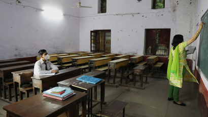 A teacher gives a lesson inside a classroom, in New Delhi