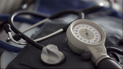 a stethoscope on a table against a blue blood pressure cuff.