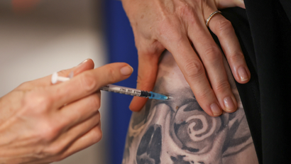 A healthcare worker administers a dose of the Pfizer-BioNTech coronavirus disease (COVID-19) vaccine to a person at the Newcastle Racecourse vaccination centre