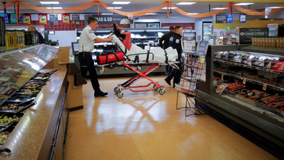 FILE PHOTO: Cataldo Ambulance medics Ricky Cormio and Luke Magnant take a 40-year-old woman out of a grocery store where she was found unresponsive in the store's bathroom after overdosing on opioids in the Boston suburb of Malden, Massachusetts, U.S. November 15, 2017. REUTERS/Brian Snyder/File Photo