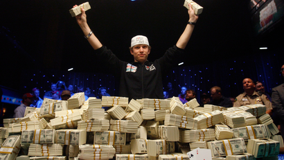 In this Nov. 11, 2008 file photo, Peter Eastgate of Denmark poses with a pile of cash after winning the World Series of Poker championship in Las Vegas. Eastgate won more than $9 million. (AP Photo/Isaac Brekken/FILE)
