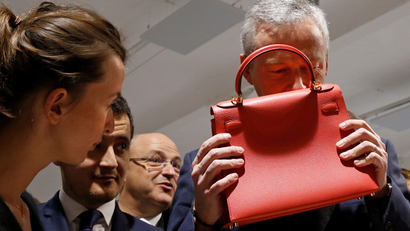 French Minister Finance Bruno Le Maire smells a leather luxury bag as he visits the new logistic hub of "Vestiaire Collective" an online marketplace to buy and sell pre-owned designer clothing and accessories, in Tourcoing, France, December 4, 2017