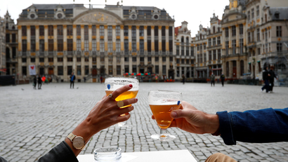 Two people having a beer in a square in Brussels