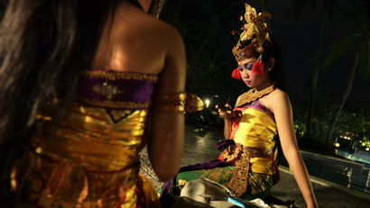 Indonesian traditional dancers using mobile phones