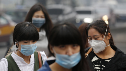 Pedestrians wearing masks walk on a street during a hazy day in Beijing October 10, 2014. Widespread smog has affected a large part of north China including capital Beijing as the National Meteorological Center (NMC) extended a yellow alert on Thursday for air pollution, Xinhua News Agency reported.