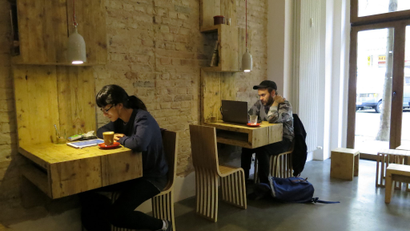 People working on laptops in a cafe.