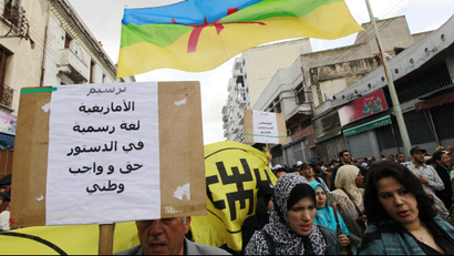 People from Amazigh, north of Morocco, hold a Amazigh flag and a banner, as they gather for a protest in Casablanca April 24, 2011. Thousands took to the streets of Morocco on Sunday in peaceful demonstrations to demand sweeping reforms and an end to political detention, the third day of mass protests since they began in February. The banner reads, "the Amazigh language is a statutory rightand acquired."