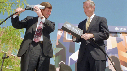 FILE--Sun Microsystems Inc. CEO Scott McNealy, left, jokes around with a fiber optic cable connection, during a news conference with Calif. Gov. Pete Wilson, right, at Sun Microsystem's Menlo Park, Calif. facility, Wednesday, Aug. 24, 1994. It has been reported that Sun Microsystems Inc. is preparing a bid for the financially struggling Apple Computers Inc. Sun's main focus is workstations and internet servers and an acquisition of Apple would give Sun access to the fast-growing market for desktop computers. (AP Photo/File, Paul Sakuma)