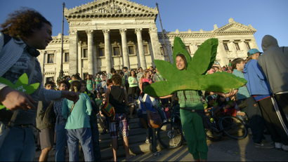 In this Tuesday, Dec. 10, 2013 photo, people attend a demonstration in support of the legalization of marijuana outside the Congress in Montevideo, Uruguay. Uruguay has become the first country to create a national marketplace for legal marijuana, with the government regulating the production, sales and use of pot in a bold bid to control addiction and drug violence. The Senate gave final legislative approval to the bill late Tuesday. (AP Photo/Matilde Campodonico)