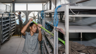 Workers clean the shelves of bitcoin-mining machines in Bitmain's mining operation in Inner Mongolia.