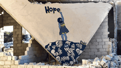Street art in Syria: Girl writing hope painted on rubble.