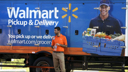 A man standing in front of a Wal-Mart delivery truck