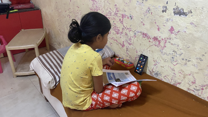 Sayi Gharat, 9, attends school online using her mother's mobile phone in Dunge village in western India. February 8, 2022. Thomson Reuters FoundationRina Chandran