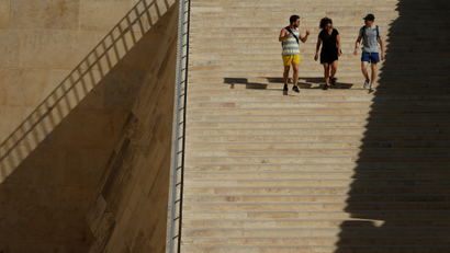 People walk down the staircase at the entrance to Valletta towards the bus terminus, outside the city walls of Valletta