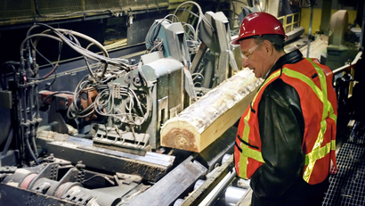 FILE PHOTO: Canadian Prime Minister Paul Martin watches logs being cut while visiting a sawmill in Richmond just south of Vancouver, British Columbia, Canada on December 14, 2005.