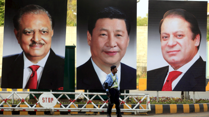 A policeman stands guard next to giant portraits of (L-R) Pakistan's President Mamnoon Hussain, China's President Xi Jinping, and Pakistan's Prime Minister Nawaz Sharif, displayed along a road ahead of Xi's visit to Islamabad April 19, 2015. Xi will visit Pakistan on April 20 on a two day official visit to meet Pakistani leadership.