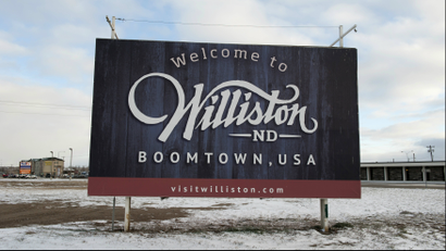 A sign reads "Welcome to Williston ND Boomtown USA" along the main road in Williston, North Dakota November 12, 2014.